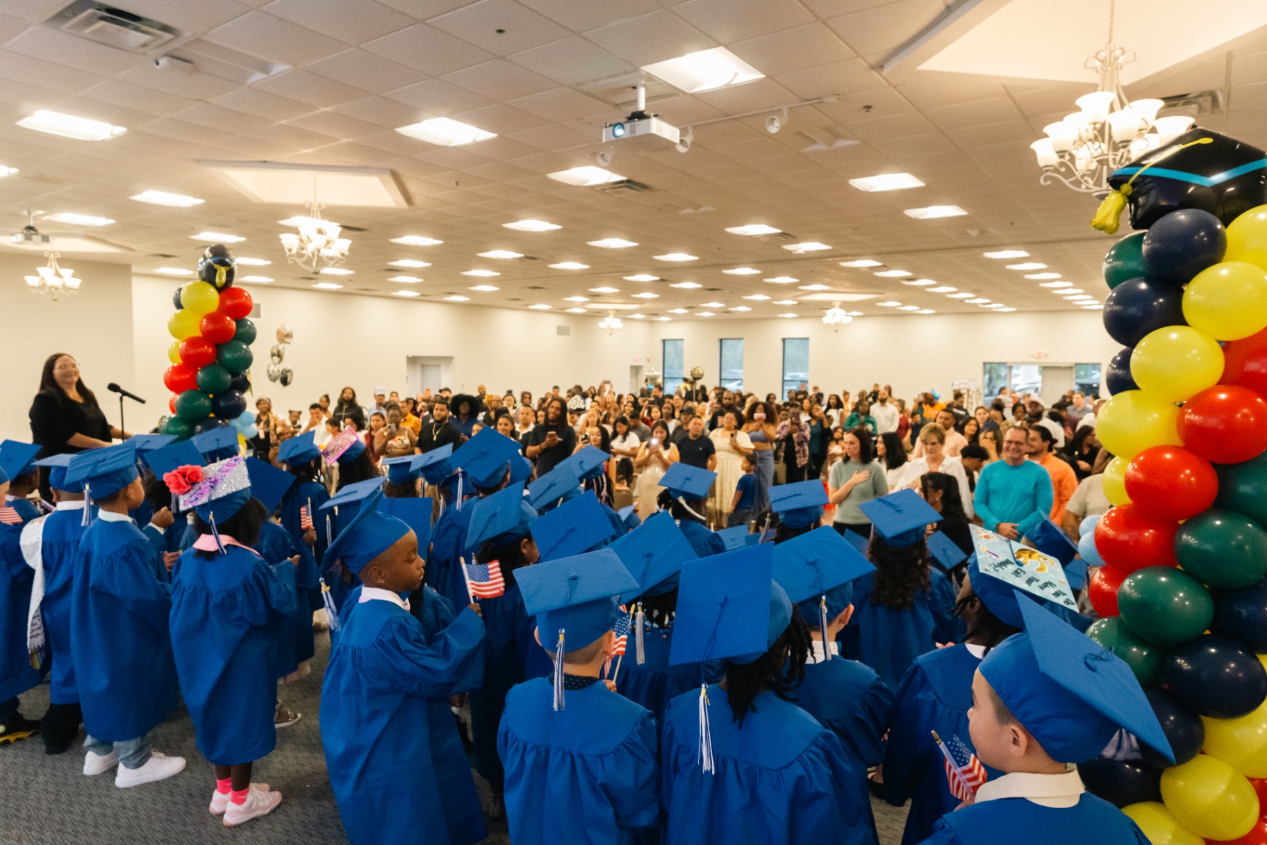 Packed VPK graduation ceremony with families and balloons